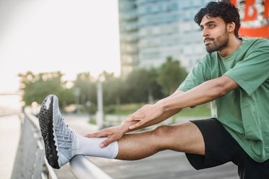 pexels-photo-5037324-5037324 Selective Focus Photo of a Man in a Green Collar Neck Shirt Stretching His Leg